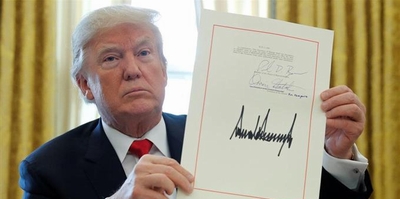 トランプ大統領が法案書に署名する写真